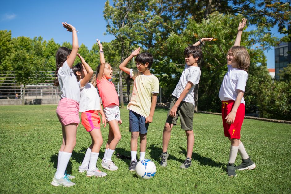 Kinder beim gemeinsamen Sport auf dem Rasen