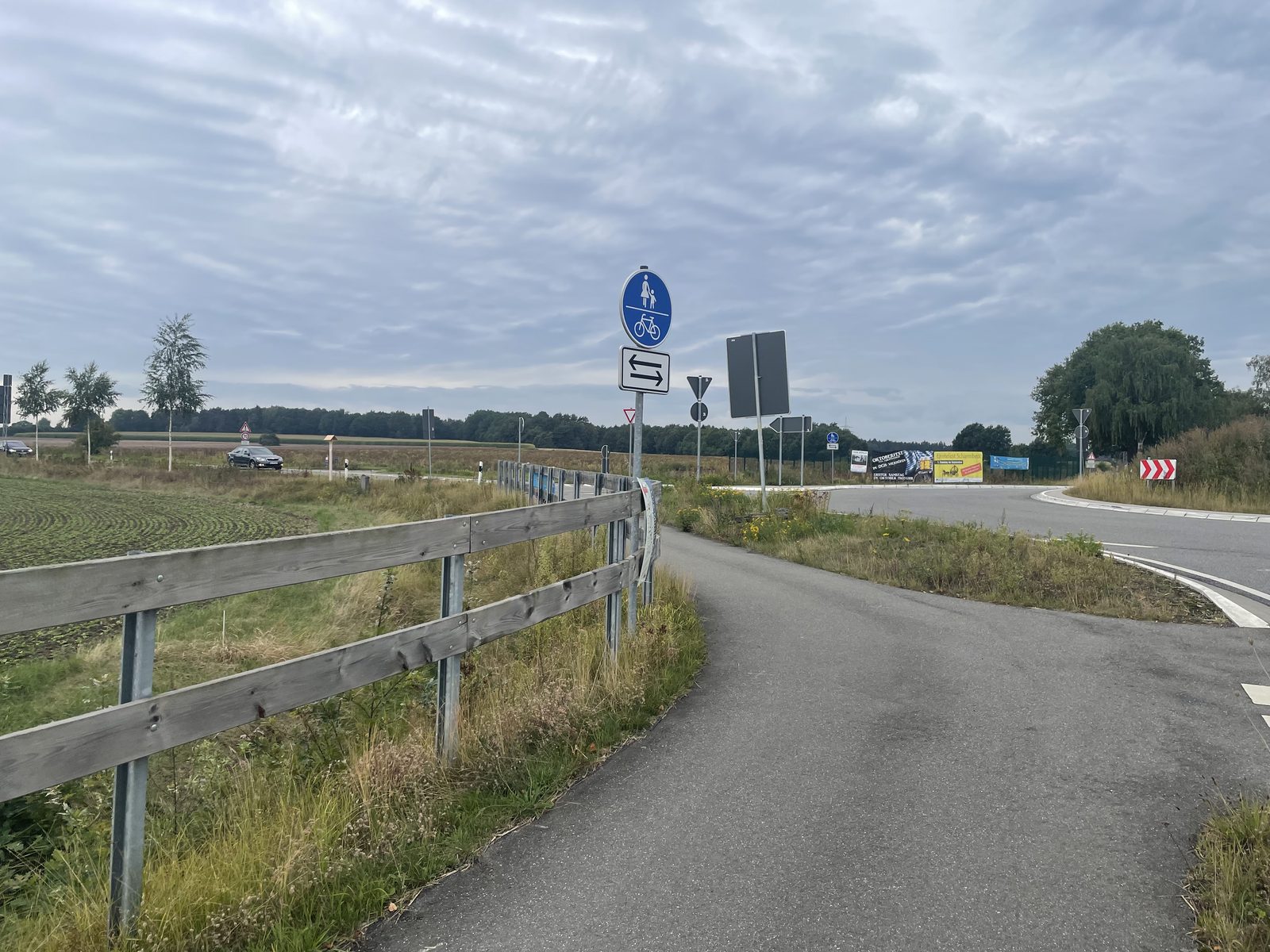 Der Weg zur Querung, ausgeschildert mit Zeichen 240 als gemeinsamer Geh- und Radweg, darunter der Zusatz f&uuml;r Radverkehr in beiden Richtungen.